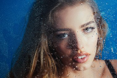 Kızın yüzüne yağmur damlası damlıyor. Makyajlı kızdan önce su damlaları.