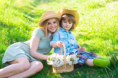 Piknikteki oğlunla Anneler Günün kutlu olsun. Parkta çimlerin üzerinde oturan çocuklu bir anne..