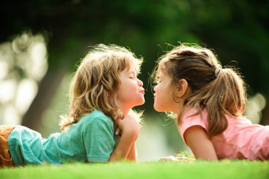Çocuk ilişkileri. Sevimli aşk. Parkta öpüşen küçük çocuklar..