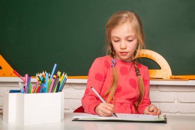 Okula dönelim. Öğrenci kız sınıfta öğreniyor. Çocuklar için eğitim.