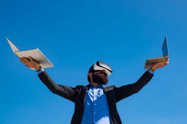 İş adamı sanal gerçekliği. Gelecekteki teknoloji konsepti. Dışarıda dizüstü bilgisayarı olan sakallı bir adam..