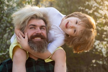 Baba oğul ilişkileri. Çocuğa sarılan baba. Babalar günün kutlu olsun. Omuz gezdirme. Arkadaş canlısı aile..