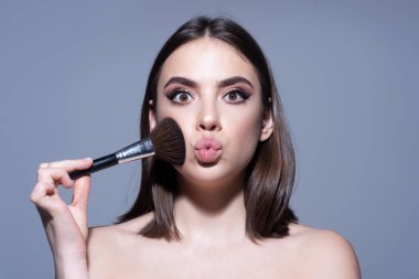 Makyajlı ve allık fırçalı tatlı bir kız. Kozmetik ürün konsepti.