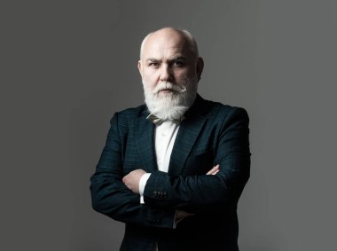 Kolları bağlı, Takım Elbiseli Adam. Sakallı, orta yaşlı, ciddi bir yüz ifadesi olan, yakın plan bir kafa ve omuz portresi olan adam..