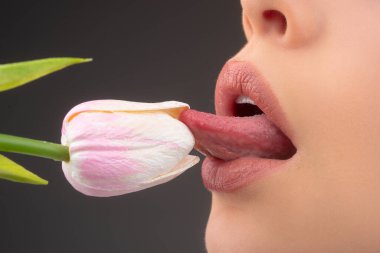 Lips and spring flower. Sexy woman mouth and flowers. Oral sex, orgasm, blowjob, licking flower. Girl lips with tulips.