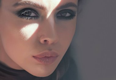 Yüzü banyoda makyajlı bir kız. Cilt bakımı, tedavi, gençleştirme. Kozmetik, güzellik, çehre. Genç yüz portresi, kadın model, güzel kadın.