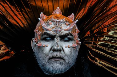 Şeytan suratlı. Dikenli ya da siğilli bir adam. Karanlık sanatlar kavramı. Canavar gibi giyinmiş beyaz sakallı şeytan adam. Kötülük siyah arka planda, kapat. Dikenli ya da siğilli bir adam. Uzaylı, şeytan, büyücü makyajı..