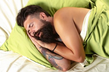 Yatakta uyumaya çalışan bir adam. Adam yatak odasında uyuyor. Yatakta yatıyor. Dinlenmem gerek..