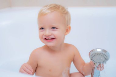 Banyoda gülümseyen bebek. Komik çocuklar eğlenceli küvet. Hijyen ve çocukların umurunda. Banyoda banyo yaparken gülümseyen sevimli küçük çocuk..