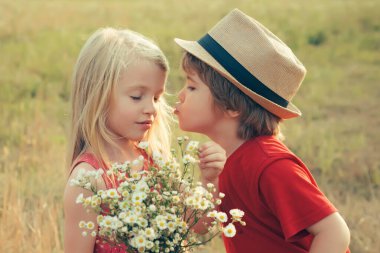 Güzel çocuklar oynar. Macera çocukları hikayeye bayılır. Güzel, küçük bir çift erkek ve kız öpüşüyor. Mutlu şirin bir çocuğun yaz portresi..