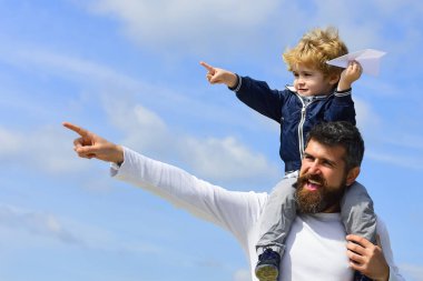 Baba ve oğul doğada oyuncak uçakla oynuyorlar. Mutlu bir aile. Çocuk kağıt uçakla oynuyor. Nesil. Ebeveynlik.