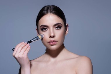 Cilt bakımı. Makyaj ve makyaj malzemeleri. Yüzüm. Makyaj fırçası olan kadın. Güzellik tedavileri.