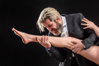 Takım elbiseli garip bir işadamı kadın bacakları yalıyor. Ayak fetişisti. Lüks ve ataerkil düzen. Erkek bacak yalar..