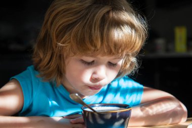 Çocukların beslenmesi. Küçük çocuk çorba içiyor. Çocuklar için sağlıklı yiyecekler. Organik ev yemeği..