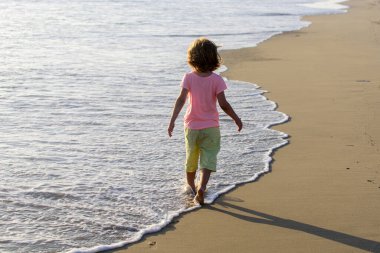 Yaz tatili. Yaz tatilinde sahilde oynayan bir çocuk..