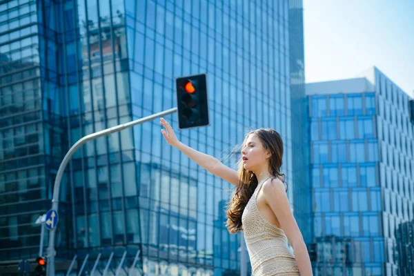 Girl get taxi. Woman catching car on city street. Travel, tourism and people concept.