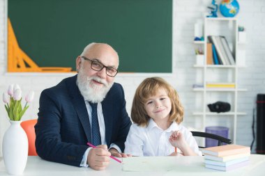 Öğrenmeme yardım et. Öğrenci çocuk dersi. Öğretmenim. Eğitim konsepti. Eski öğretmen ve okul çocuğu sınıfta..