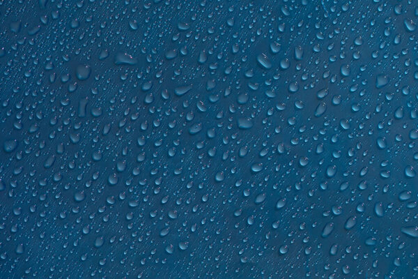 Drops abstract texture. Wet water on blue glass background. Bubble pattern.