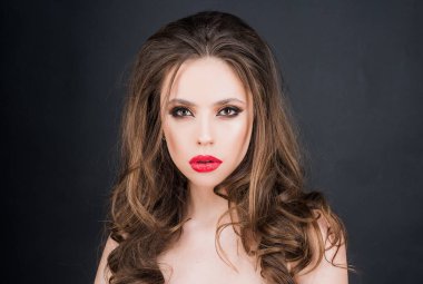 Yakından bir güzellik portresi. Kırmızı dudak makyajı. Parlak makyajlı genç bir kadın. Kırmızı ruj parlatıcısı..