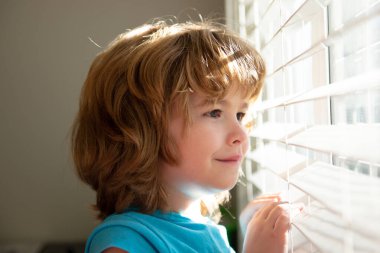 Koru kendini. Evde tek başına kal. COVID-19 tecrit. Pencereden bakan çocuk. Karantina konsepti. Koronavirüs salgını.