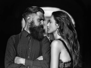 Uzun sakallı yakışıklı bir çift ve seksi bir kadın. Açık havada kemer ve fotokopi uzayı ile birlikte duruyorlar.