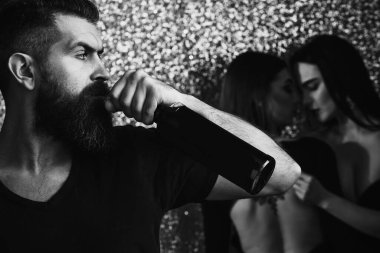 Şişeli sarhoş adam. Hippi, parıltılı arka planda seksi kadınlarla şarap içer. Aşk, aşk, ilişki, yaşam tarzı. Parti bayramı kutlaması.