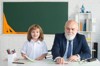 Okuldaki mutlu çocuk. Öğretmenin öğrenmesine yardım et. Eğitim, öğretmenlik, ilkokul.