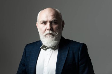 Gri bir stüdyo arka planında orta yaşlı sakallı bir adamın portresi. Ciddi kıdemli adam..