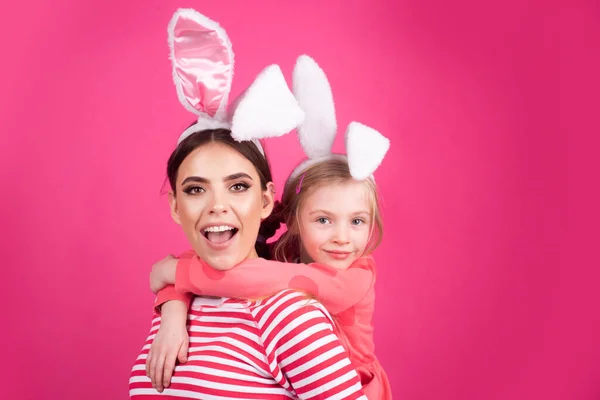 Girl friends happy easter. Happy childhood concept. Small sister female bunny ears isolated on pink background.