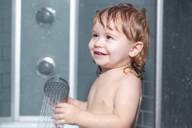 Çocuk sağlığı hizmetleri. Mutlu bebek köpüklerle oynayarak banyo yapıyor. Küvette küçük bir çocuk. Banyoda gülümseyen çocuk. Bebek yıkama ve banyo. Çocuklar bakım ve hijyen yapar..