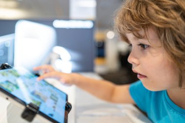 Bilgisayar dükkanındaki çocuk. Dijital ekipman ve elektronik aletler. Dizüstü bilgisayar satışı.