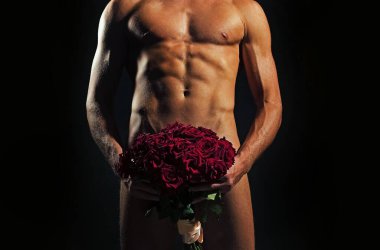 Cinsel organında gül buketi olan bir adam. Seksi, çıplak bir beden. Banyo havlusunda kaslı, ıslak vücutlu bir adam. Siyah arka planda atletik eşcinsel adam.