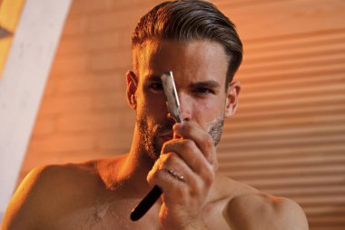 Sakallı adam banyoda jiletle tıraş oluyor. Traş, berber, berber. Sakalında sabun olan bir maço..