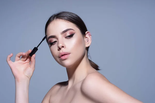 Beauty and Cosmetics. Woman Putting Black Mascara On Eyelashes. Perfect Makeup.