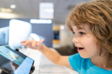 Alet dükkanındaki çocuk. Elektronik alışveriş merkezi. Akıllı teknikleri seç. Bilgisayar dükkanındaki çocuk. Dijital ekipman. Gadget satışı.