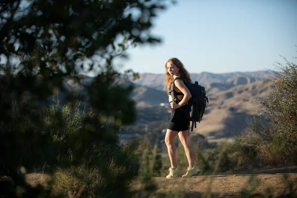 Pěší turistka hora s batohem. Sportovní dívka se dívá na ohromující a divokou krajinu na panoramatickém místě. Backpacking cestovní ruch. — Stock fotografie