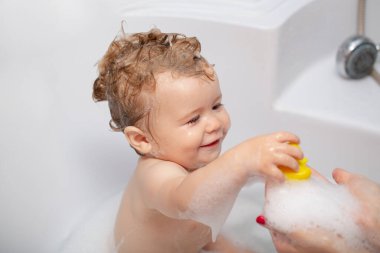 Banyo yapan bebek. Kafasında köpük olan mutlu çocuk. Çocuk köpük banyosu.