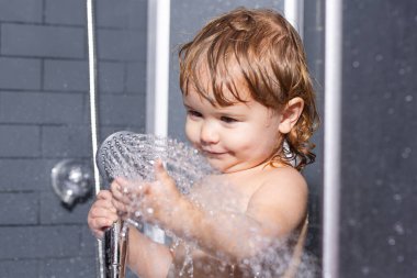 Bebek hijyeni ve sağlık hizmetlerini yıka. Banyoda güzel bir bebek yıkıyorum. Saçında sabun köpüğü olan çocuk banyo yapıyor. Komik çocukların yüzü yakın plan..