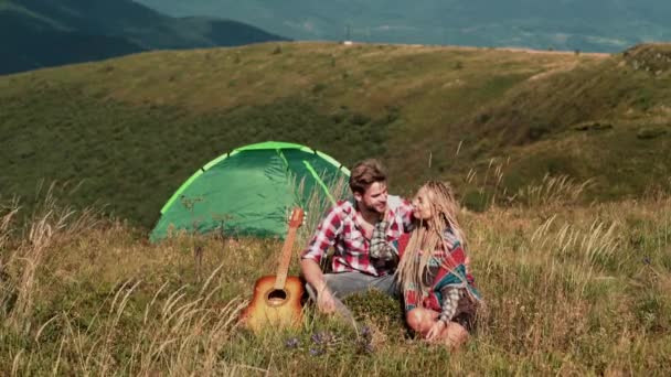 Couple camping in love in mountains. Summer Travel Vacation. Happy Man Playing Guitar for Girlfriend. — Stock Video