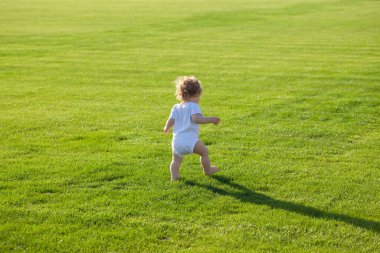 Bebek bezi pantolonuyla parkta yürürken. Sağlıklı çocuk.