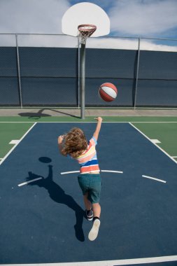 Basketbolcu çocuklar antrenman yapıyor. Sevimli küçük çocuk basket topuyla basket atıyor. Aktif çocuk yaşam tarzı.