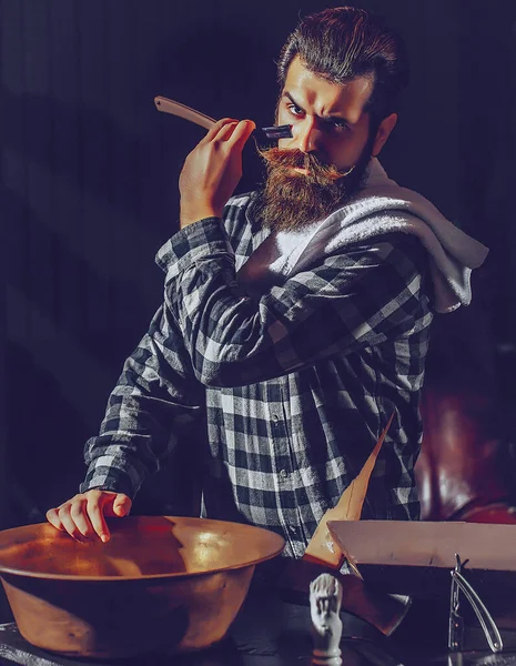 Bearded man shaves with razor. Barber with vintage razor, shaving brush and foam. Bearded man, bearded gay. Modern man with classic long beard. Barber straight razor, barbershop.