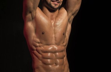 Çocuk güçlü. Erkeklerin cilt bakımı. Siyah arka planda kaslı vücudu olan çıplak bir erkek göğsü. Seksi kaslı erkek model güçlü çıplak vücut.