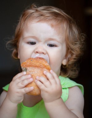 Şirin bebek çok açgözlü, aç ve mutlu bir beyaz ekmek yiyor..