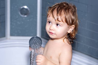 Küvette yeni yürümeye başlayan bir çocuk. Bebek banyoda köpükle yıkanıyor..