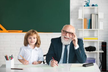 Okuldaki mutlu çocuk. Öğretmenin öğrenmesine yardım et. Eğitim, öğretmenlik, ilkokul