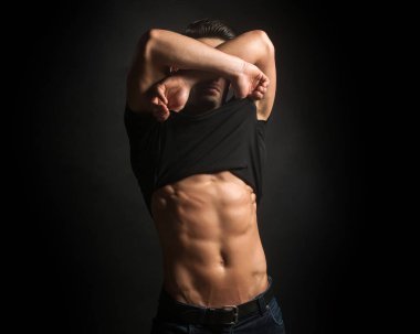 Siyah gömlekli, kaslı ve güzel vücutlu seksi, şık, düşünceli bir adam.