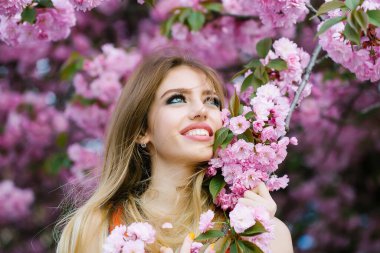 Çiçek açan bir çiçek bahçesinde güzel, narin bir genç kız.