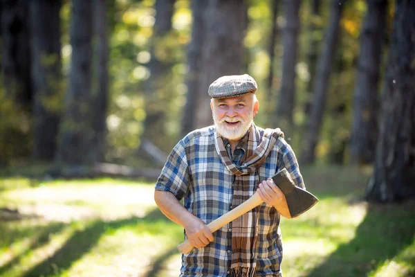 Hiking in deep wood. Sunny weather. Portrait of smiling man. Fashion portrait man. Natural background. Old bearded man with axe. Human and nature. Funny bearded forester. — Stock Photo, Image