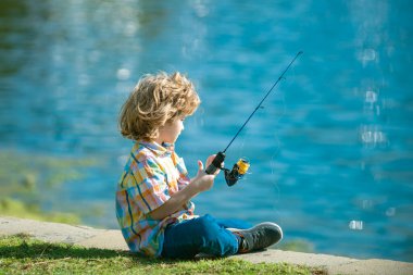 Balıkçılık hobisi. Nehirde dönen çocuk. Rıhtımdaki çubuklu çocuk..